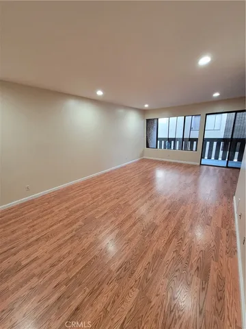 a view of empty room with wooden floor and staircase