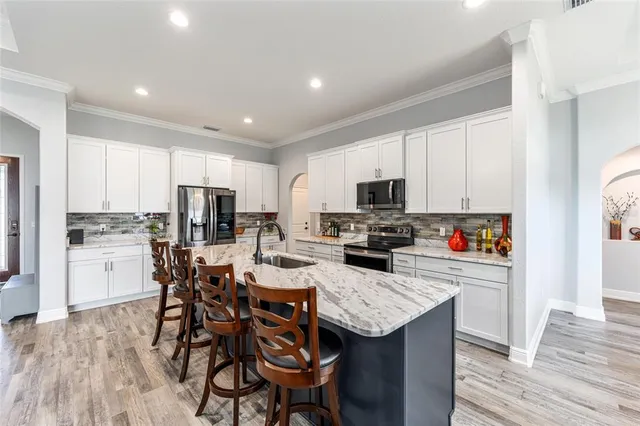 a kitchen with stainless steel appliances kitchen island granite countertop a refrigerator and microwave