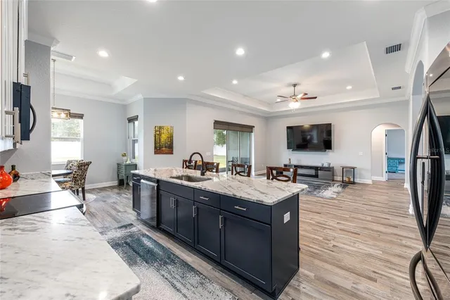 a large kitchen with stainless steel appliances a stove a sink dishwasher and a flat screen tv