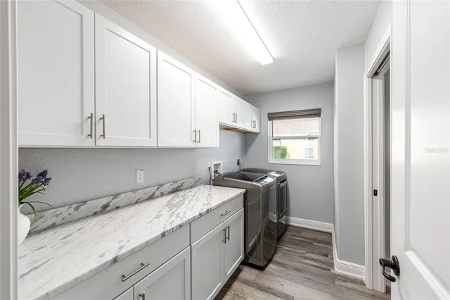 a kitchen with granite countertop white cabinets and white appliances