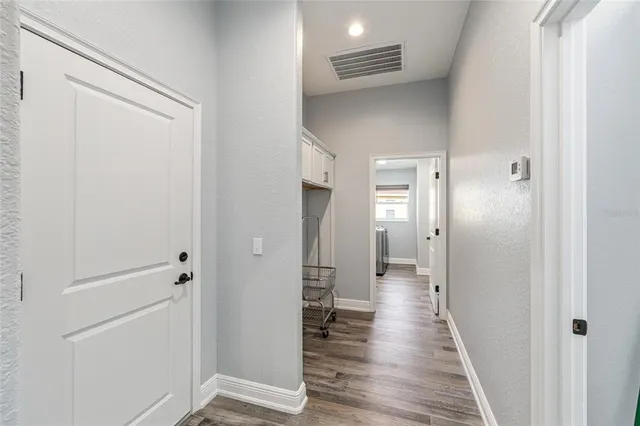 a view of a hallway with wooden floor