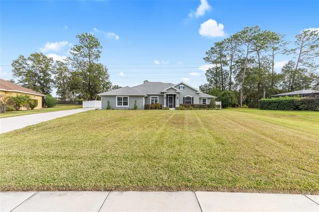 a front view of house with yard and trees around