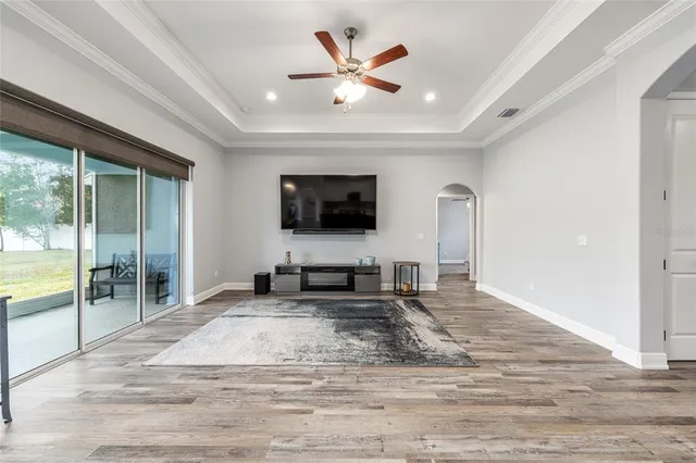 a living room with furniture a flat screen tv and a large window