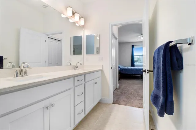 a en suite bathroom with a double vanity sink and a mirror