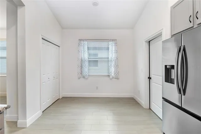 a view of a refrigerator in kitchen and a window