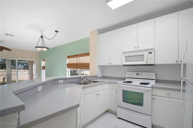 a kitchen with granite countertop a sink cabinets and window