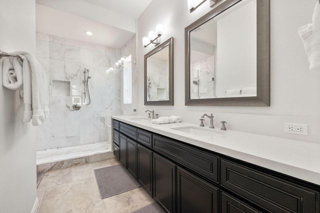 a bathroom with a double vanity sink mirror and shower