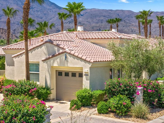 a front view of a house with a yard and potted plants