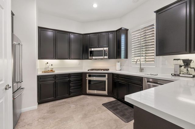 a kitchen with stainless steel appliances granite countertop a stove top oven sink and refrigerator