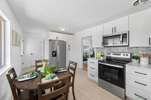 a kitchen with stainless steel appliances a stove a table and chairs
