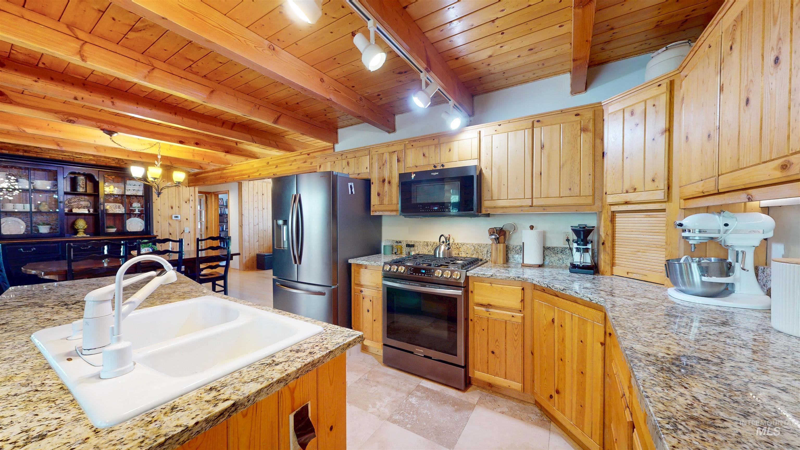 1314 River Road Buhl, ID 83316 - Photo 14 of 45 Kitchen with stainless steel appliances, a wood ceiling with exposed beams, a chandelier, track lighting, and decorative light fixtures