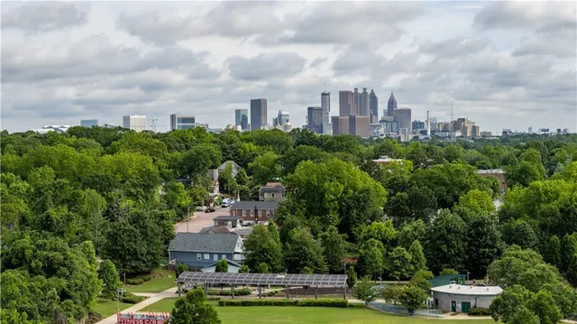 an aerial view of a city with lots of residential buildings ocean and mountain view in back