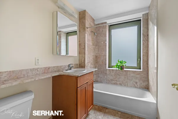 a bath room with a granite countertop sink and a bathtub