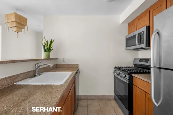 a kitchen with stainless steel appliances granite countertop a sink stove and refrigerator