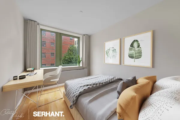 a bed sitting in a bedroom next to a window