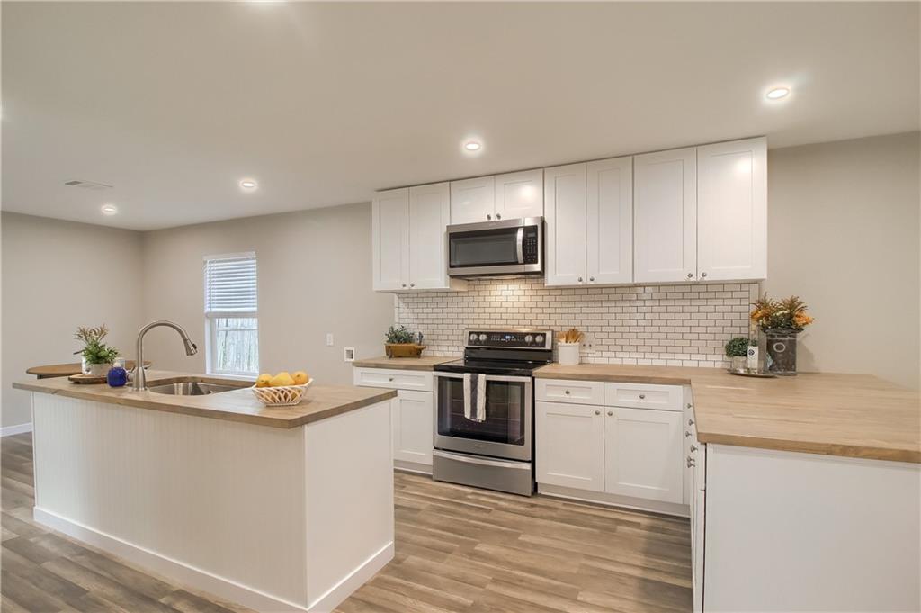 a kitchen with a sink a stove top oven and cabinets