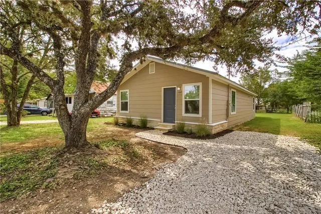 a view of a yard with a house and a large tree