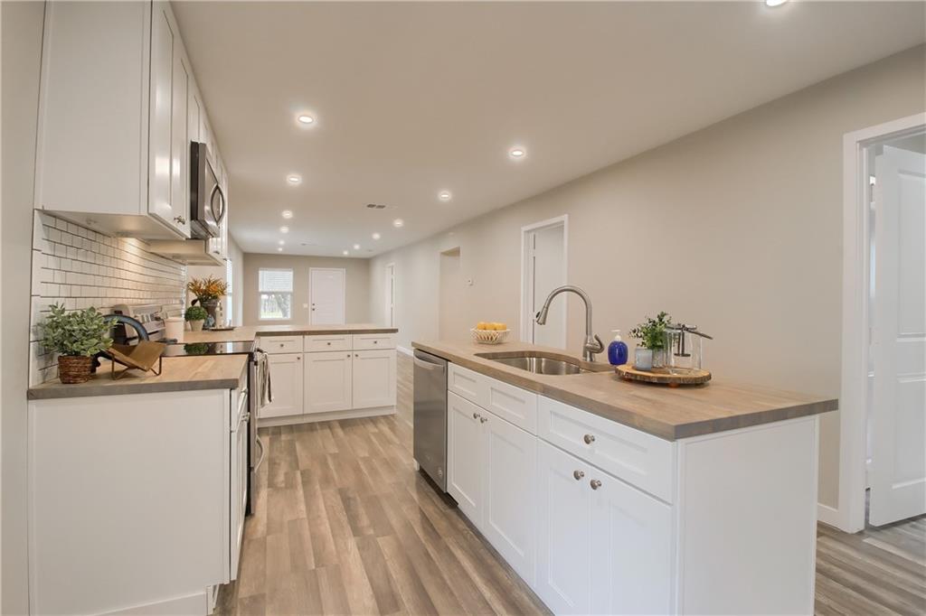 108 Irene Street Elgin, TX 78621 - Photo 3 of 22 a kitchen with white cabinets and white appliances