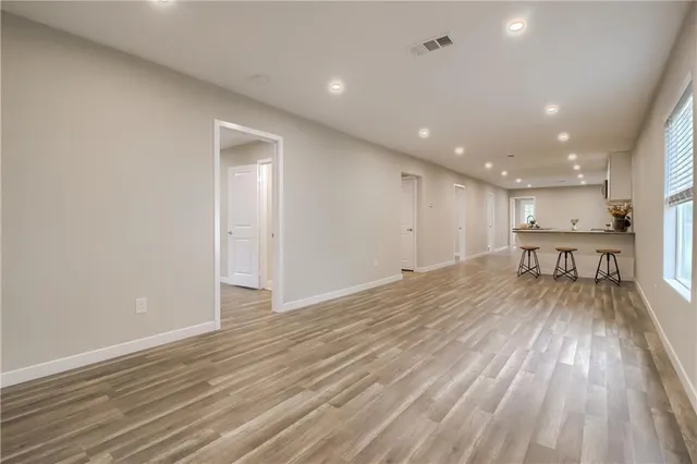 a view of empty room with window and wooden floor