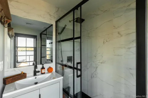 a bathroom with a tub sink and mirror