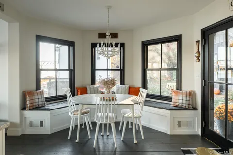 a view of a dining room with furniture large windows and wooden floor