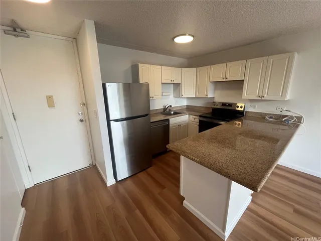 a kitchen with a sink a refrigerator a microwave and cabinets