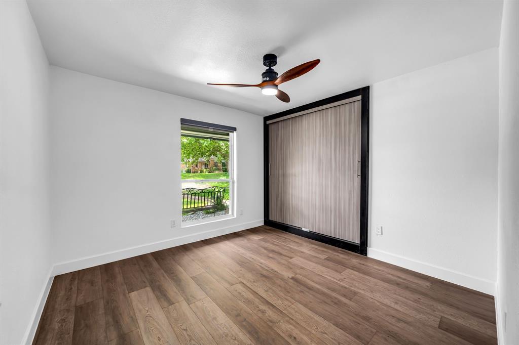 4122 Azalea Lane Garland, TX 75043 - Photo 16 of 26 an empty room with wooden floor chandelier fan and windows