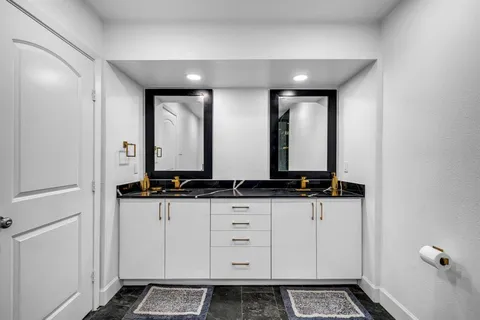 a bathroom with double sink and a mirror
