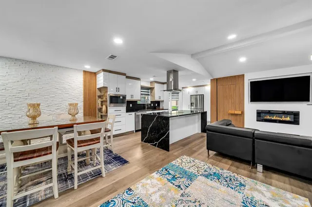 a kitchen with stainless steel appliances kitchen island granite countertop a refrigerator and a stove top oven