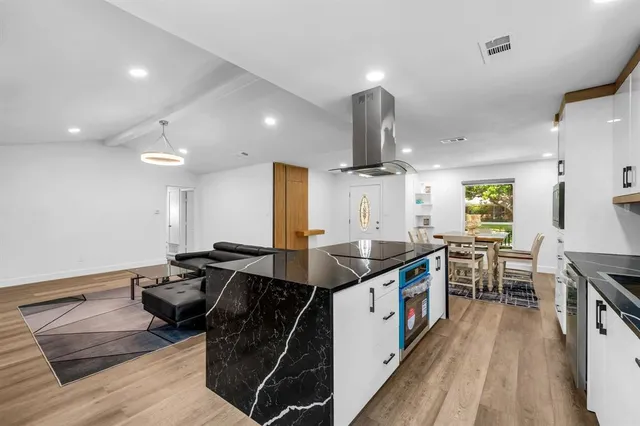 a kitchen with stainless steel appliances granite countertop a sink and a stove