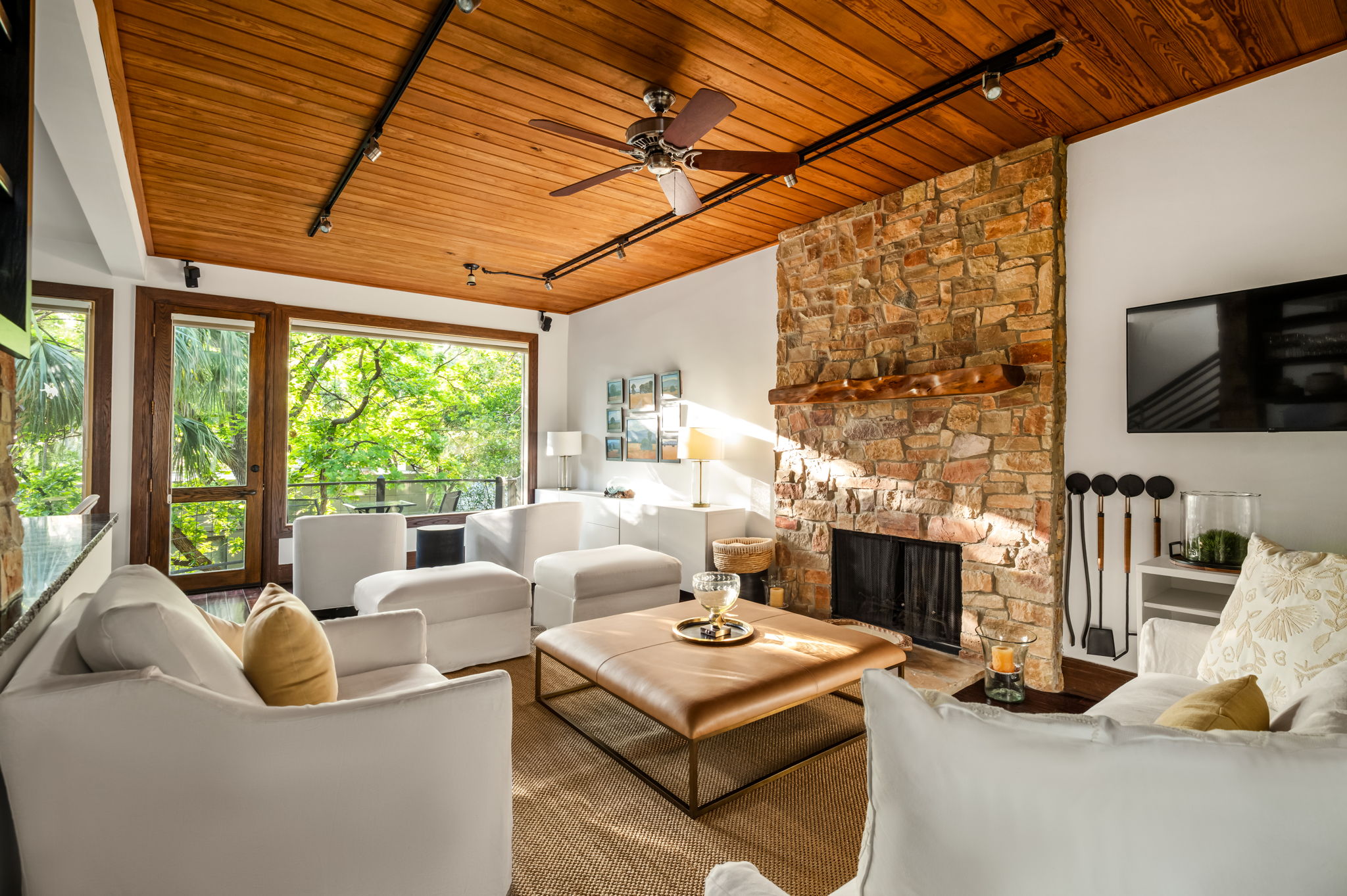 1111 West 12th Street, Unit 107 Austin, TX 78703 - Photo 23 of 38 Living area with a stone fireplace, wood-finish ceiling, and expansive windows