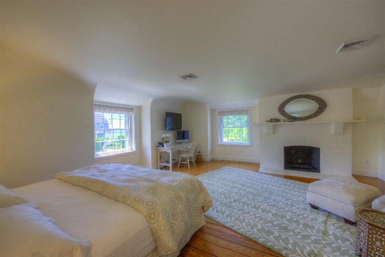 150 Sea View Avenue Osterville, MA 02655 - Photo 9 of 26 a spacious bedroom with a bed and a fireplace
