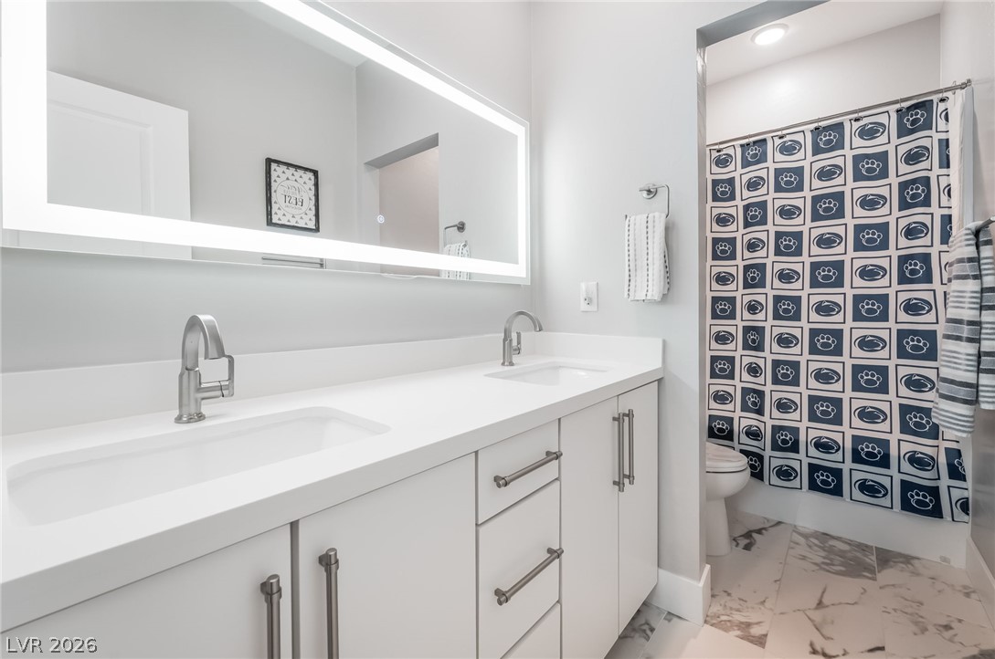 2166 Trivero Street Henderson, NV 89044 - Photo 24 of 61 Dual vanities with modern fixtures provide ample space in this well-appointed bathroom.