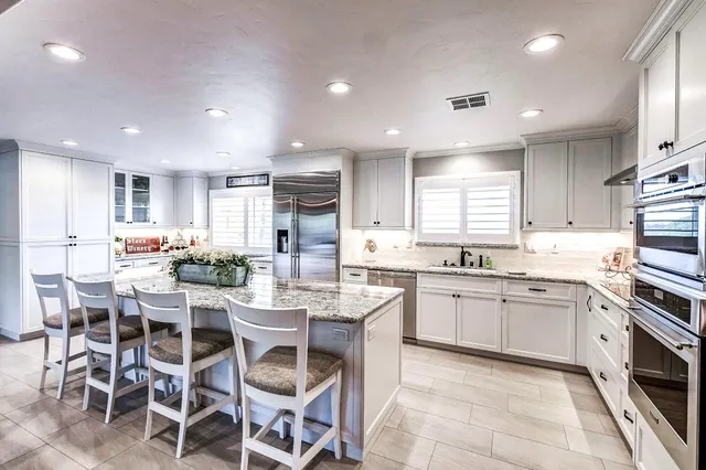 a kitchen with granite countertop white cabinets and white appliances