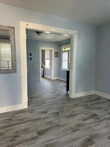 an empty room with wooden floor and mirror