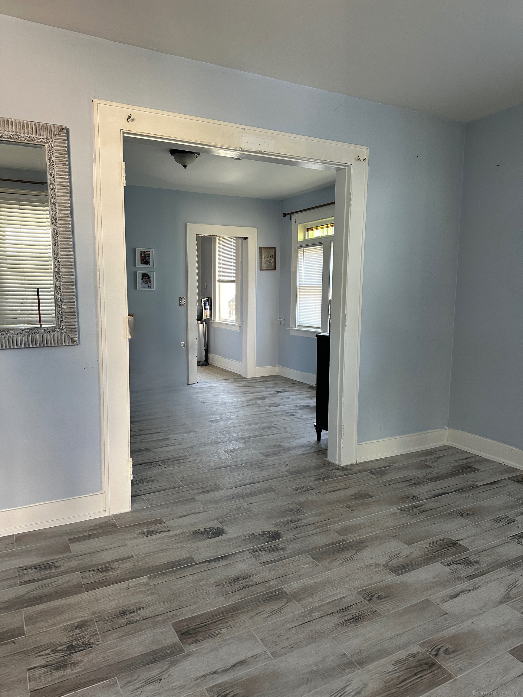 194 Adams Street Bridgeport, CT 06607 - Photo 13 of 17 an empty room with wooden floor and mirror