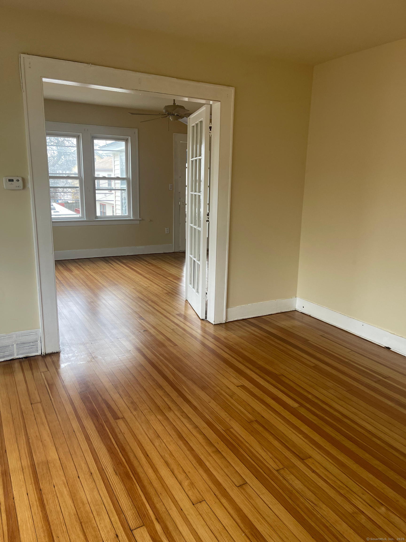 194 Adams Street Bridgeport, CT 06607 - Photo 5 of 17 a view of an empty room with wooden floor and a window