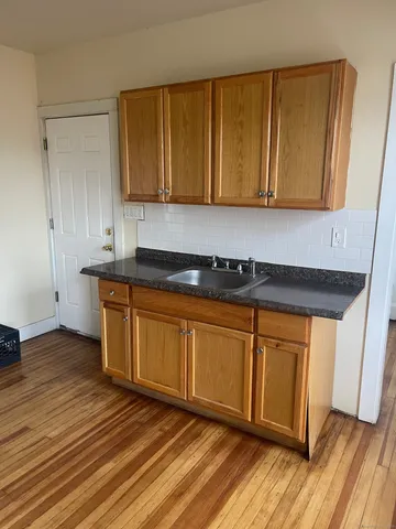 a view of a kitchen with wooden floor and cabinets