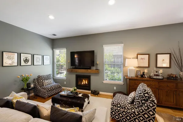a living room with furniture a flat screen tv and a fireplace
