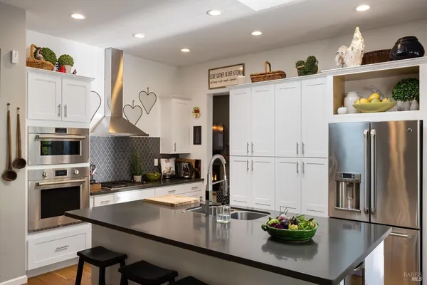 a kitchen with stainless steel appliances granite countertop a sink refrigerator and microwave