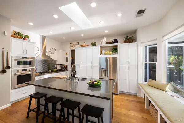a kitchen with refrigerator and chairs