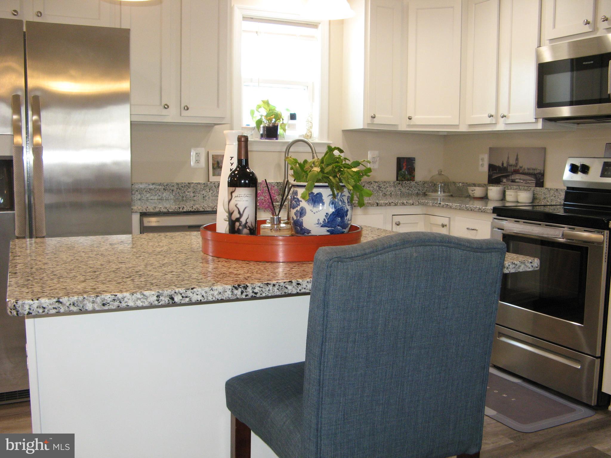 57 Oak Lane Colonial Beach, VA 22443 - Photo 16 of 47 a kitchen with granite countertop a refrigerator a stove a sink and white cabinets