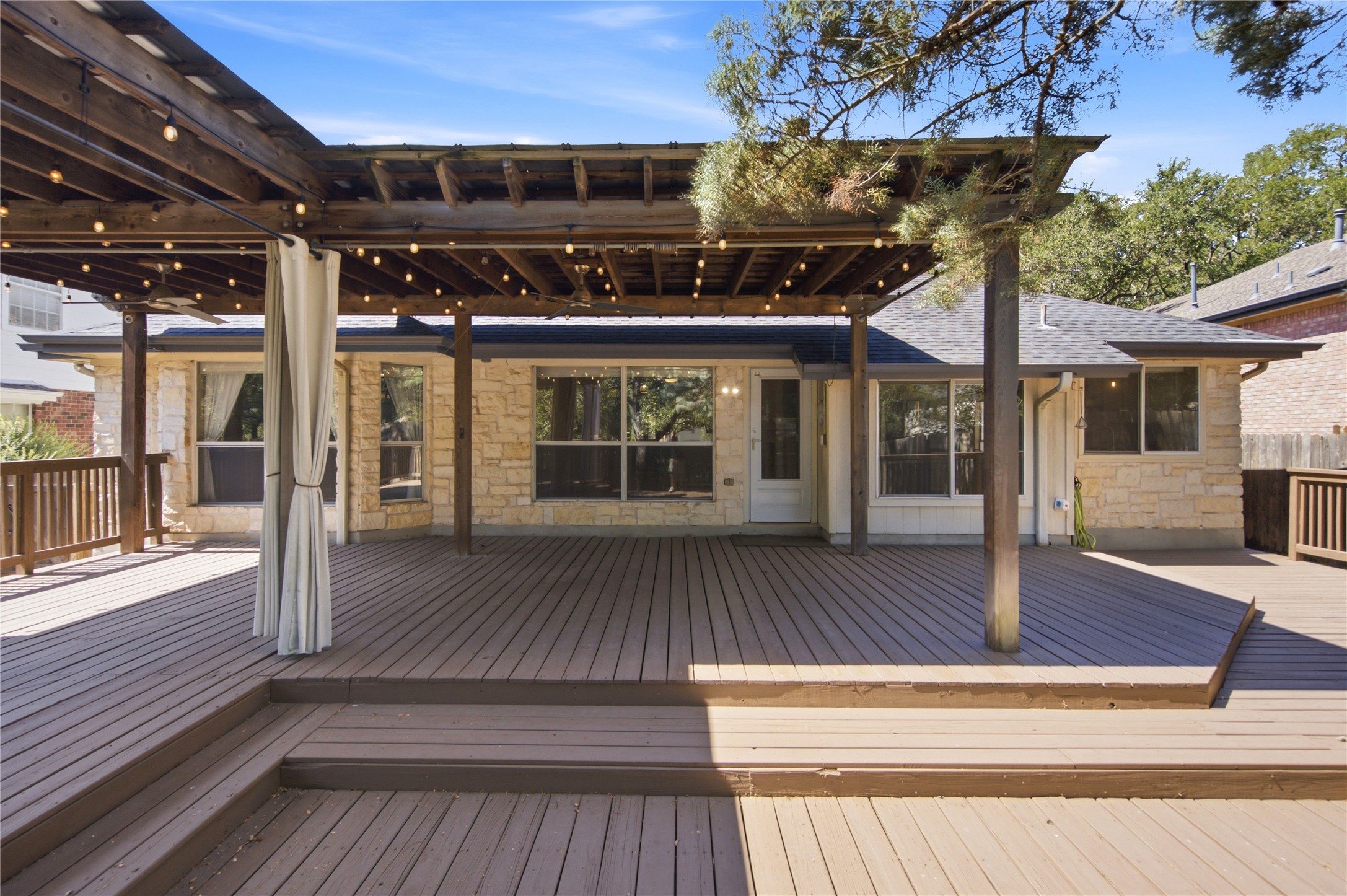6032 Roxbury Lane Austin, TX 78739 - Photo 27 of 34 An expansive multi-level wooden deck features a large overhead pergola structure.