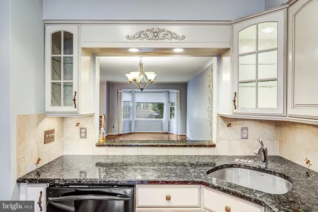 a kitchen with granite countertop a sink stainless steel appliances cabinets and a counter top space