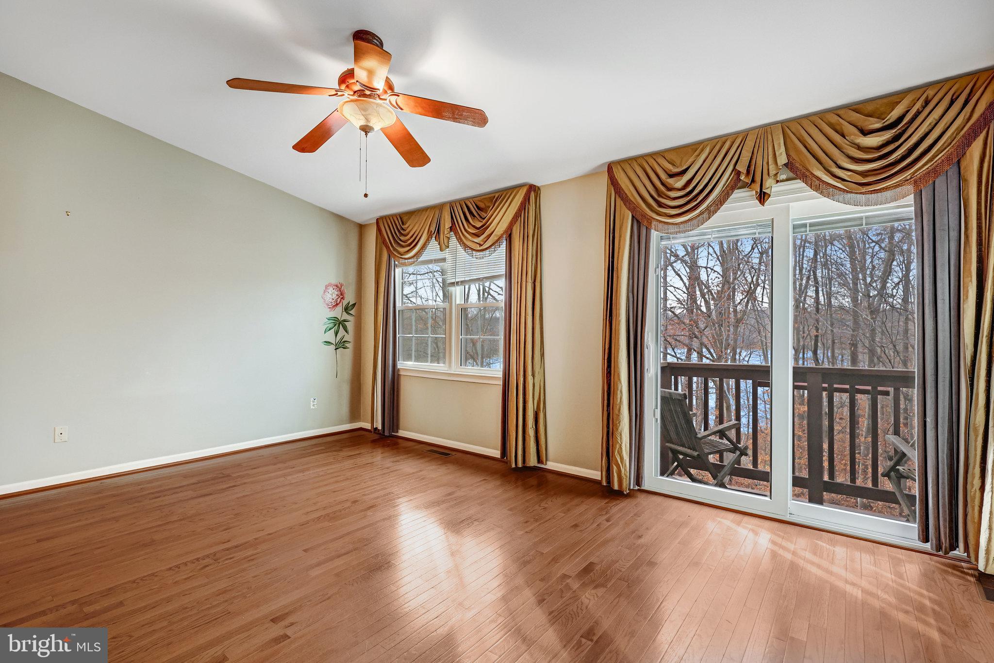 8046 Galla Knoll Circle Springfield, VA 22153 - Photo 14 of 38 an empty room with wooden floor fan and windows