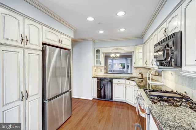 a kitchen with stainless steel appliances granite countertop a refrigerator stove and sink