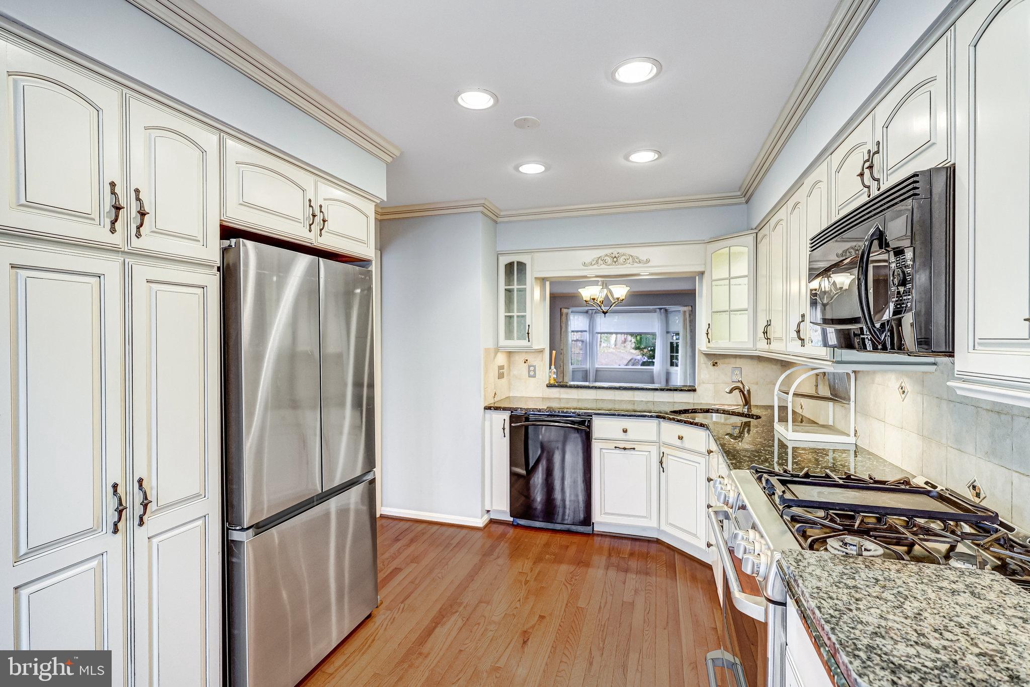 8046 Galla Knoll Circle Springfield, VA 22153 - Photo 10 of 38 a kitchen with stainless steel appliances granite countertop a refrigerator stove and sink
