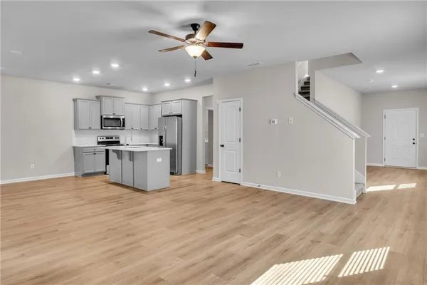 a view of kitchen with stainless steel appliances refrigerator stove microwave and cabinets