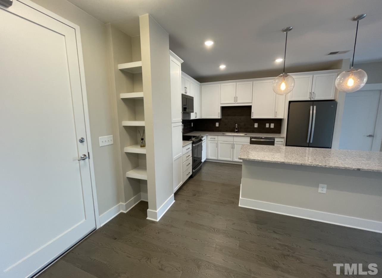 a large kitchen with a large window and stainless steel appliances