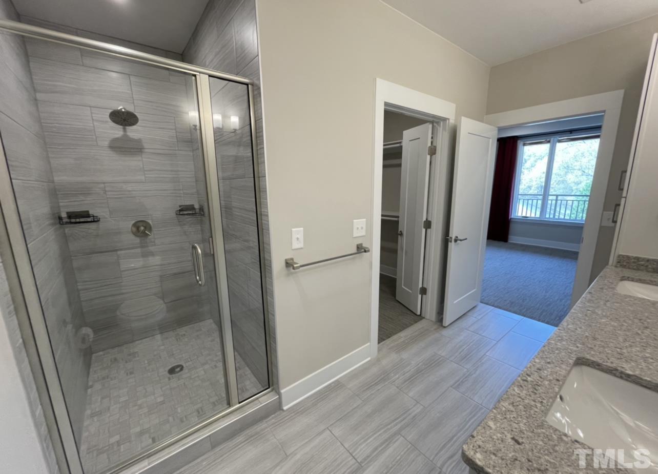 105 Chatham Walk Lane, Unit 404 Cary, NC 27511 - Photo 15 of 33 a bathroom with a glass shower door and a window